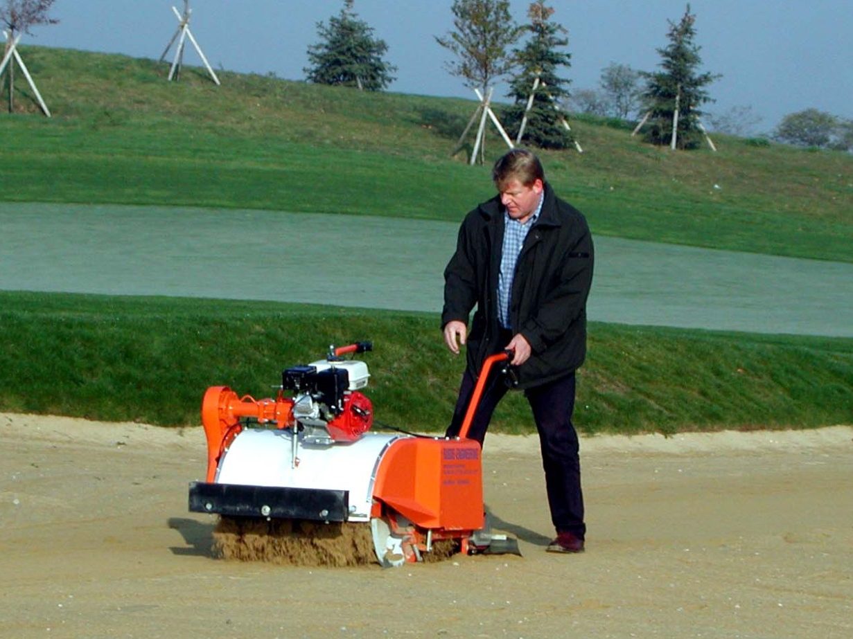 Ergebnis der Sandreinigung, Steine, Scherben, Blätter,  und Wurzeln wurden aus der Sandfläche ausgesiebt und liegen im Auffangbehälter.  